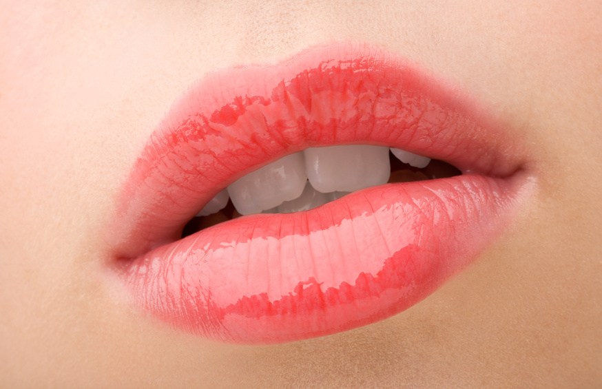 A close up of a young woman's lips with high shine lip gloss